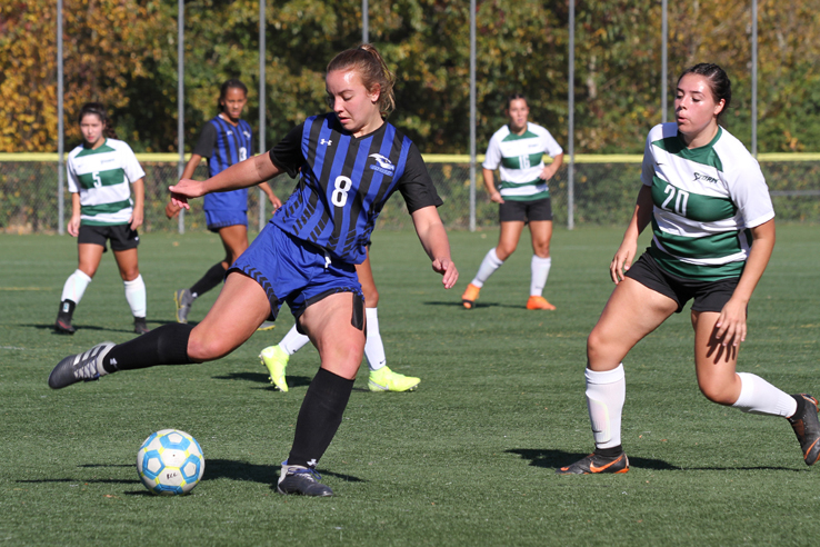 A player kicks a soccer ball