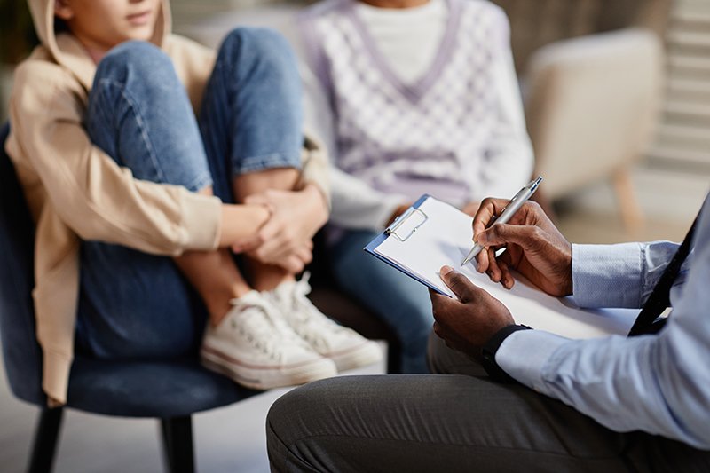 Individual taking notes in a counseling session